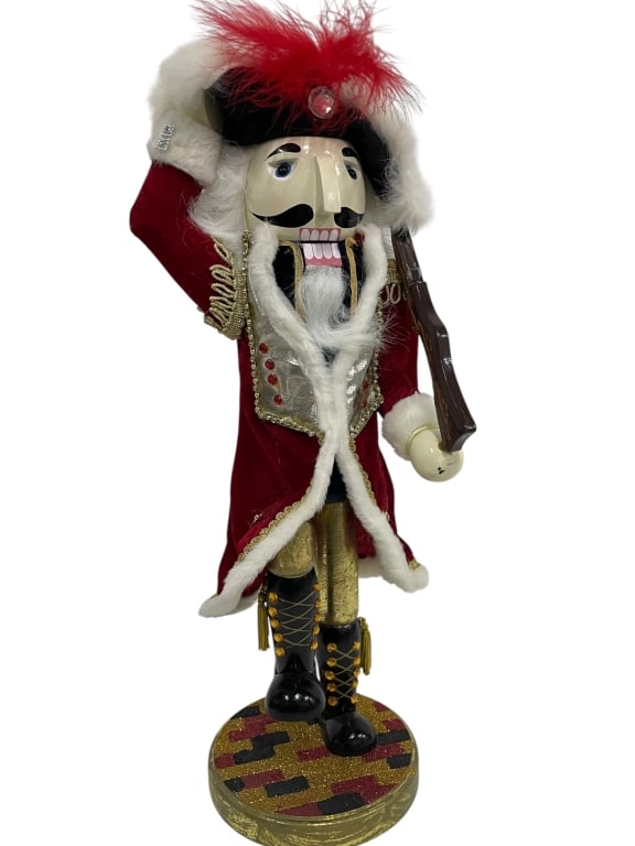 VINTAGE MAJESTIC WOODEN NUTCRACKER 21": HANDSOME AND MAJESTIC, THIS VINTAGE WOODEN NUTCRACKER STANDS TALL AT APPROXIMATELY 21" TO THE TIP OF HIS REGAL RED FEATHERED HAT. DRESSED IN AN OPULENT RED VELVET COAT TRIMMED WITH FAUX FUR AND GOLD B