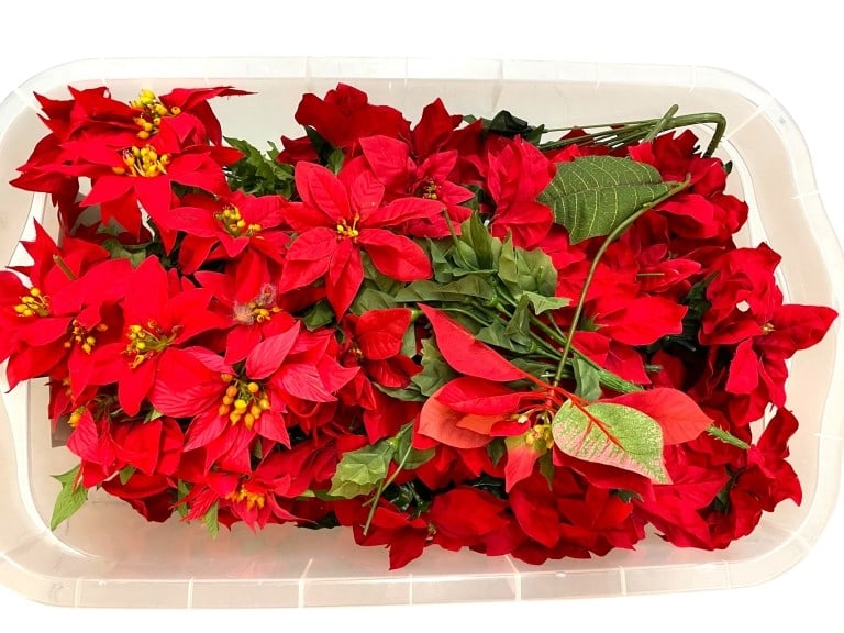 BIN OF ARTIFICIAL RED POINSETTIAS: BIN OF ARTIFICIAL RED POINSETTIAS -GOOD PRE OWNED CONDITION, SEE PHOTOS -LOT OF ARTIFICIAL RED POINSETTIAS.THIS COLLECTION OF ARTIFICIAL FLOWERS IS PERFECT FOR HOLIDAY DECORATING, CRAFT PROJECTS, OR S