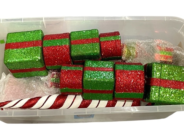 BIN OF GLITTERED CHRISTMAS DECOR: BIN OF GLITTERED CHRISTMAS DECOR -VARYING CONDITIONS, SEE PHOTOS -FESTIVE HOLIDAY ACCENTS INCLUDING RED AND GREEN FOAM PRESENTS WITH SPARKLING FINISHES, PLUS STRIPED CANDY CANE-THEMED DECOR PIECES. ID