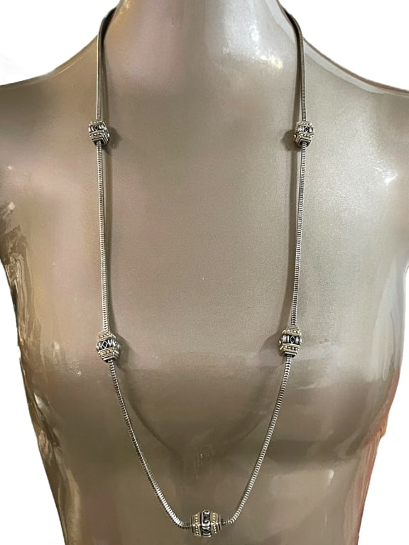 VINTAGE LONG SILVER NECKLACE W/ GOLD ACCENTS: VINTAGE LONG SILVER NECKLACE W/ GOLD ACCENTS -VERY GOOD PRE OWNED CONDITION -APPROX 17" -TIMELESS AND VERSATILE, THIS SILVER LONG NECKLACE FEATURES A SLEEK SNAKE CHAIN DESIGN ACCENTED WITH INTRICATELY