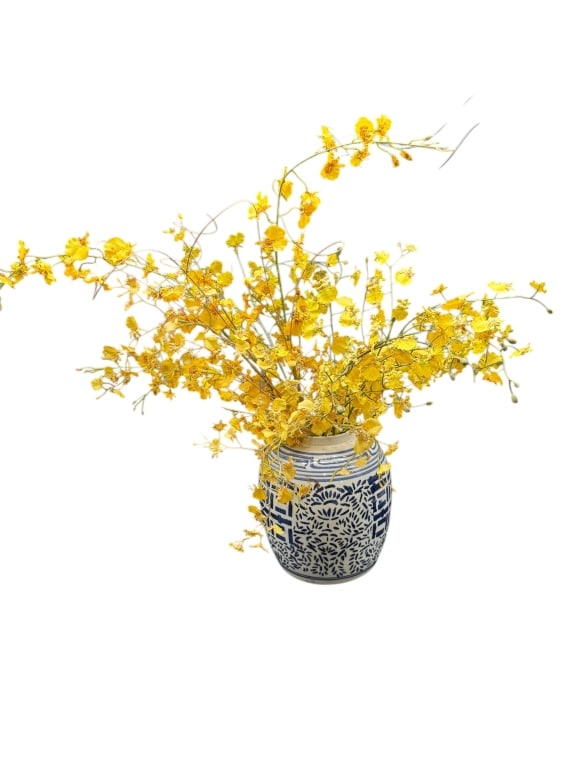 BLUE AND WHITE VASE WITH YELLOW ORCHIDS: BLUE AND WHITE VASE WITH YELLOW ORCHIDSA striking blue and white ceramic vase with traditional geometric and floral motifs, paired with an abundant arrangement of bright yellow faux orchids. The vase