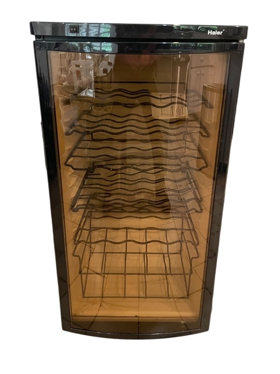HALER WINE COOLER REFRIGERATOR 28": HALER WINE COOLER REFRIGERATOR – COMPACT WINE FRIDGE WITH GLASS DOORHaier wine cooler refrigerator with black finish and smoked glass front door. Interior includes multiple removable wave-form wire