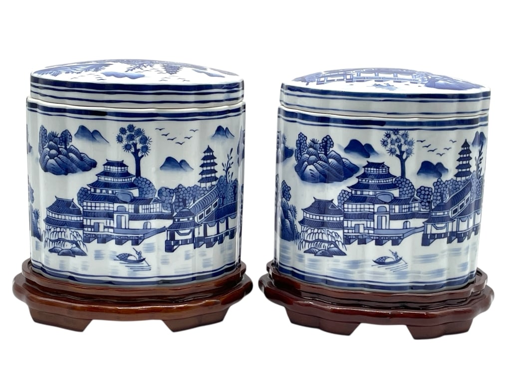 PAIR OF BOMBAY COVERED PORCELAIN JARS 10": PAIR OF BOMBAY BLUE AND WHITE COVERED PORCELAIN JARS WITH LANDSCAPE SCENES ON WOOD BASES -Very good pre owned condition -Approx 10"h x 9"w x 6"d -A refined pair of Chinese style blue and white porcela