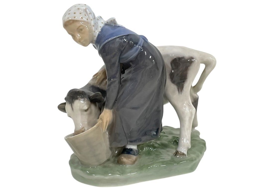 ROYAL COPENHAGEN FIGURINE OF GIRL FEEDING A CALF: ROYAL COPENHAGEN PORCELAIN FIGURINE OF A GIRL FEEDING A CALF FROM A BUCKET -VERY GOOD PRE OWNED CONDITION -APPROX 6"L X 6.5"H -A BEAUTIFULLY DETAILED PORCELAIN SCULPTURE DEPICTING A YOUNG GIRL IN TRAD