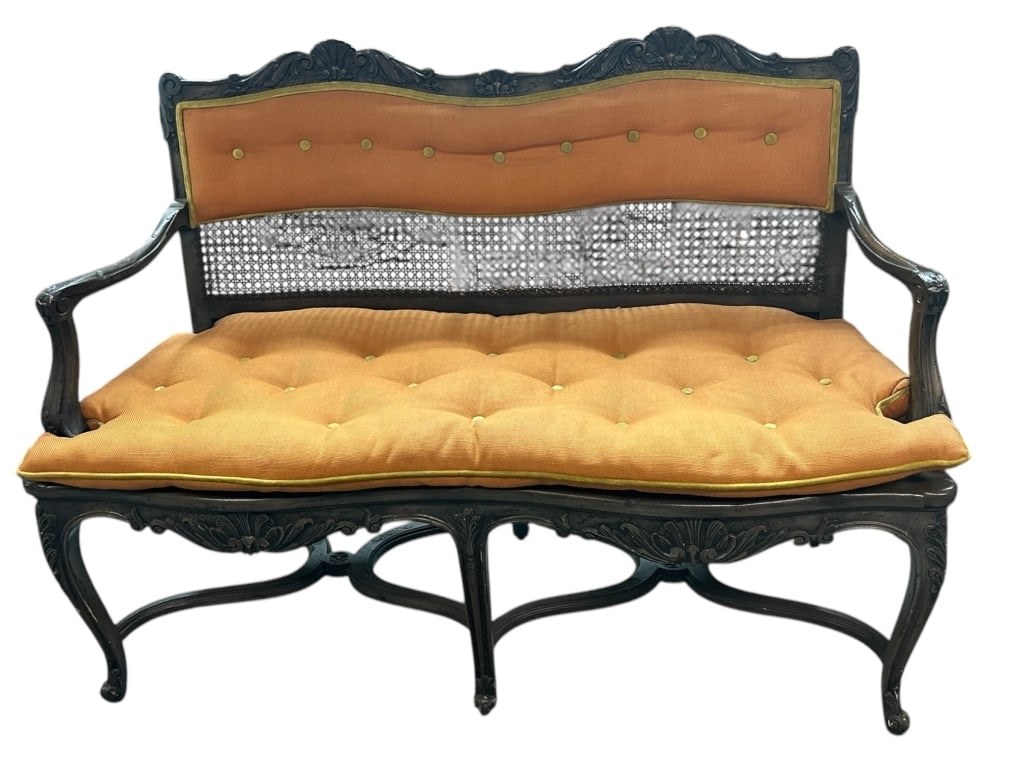 ELEGANTLY CARVED WOOD SETTEE: - ELEGANTLY CARVED WOOD SETTEE FEATURING A DARK FINISH WITH INTRICATE FLORAL DETAILS AND CANED BACK PANEL. THE FRAME IS COMPLIMENTED BY A TUFTED ORANGE CUSHION WITH MATCHING BACK PANEL ACCENTED BY CON