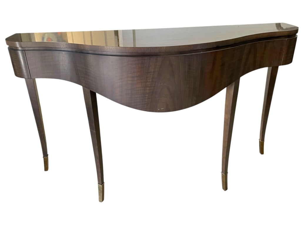 CURVED FRONT WALNUT CONSOLE TABLE 59.5": CURVED FRONT WALNUT CONSOLE TABLE WITH BRASS CAPSELEGANT SERPENTINE-FRONT CONSOLE TABLE FEATURING RICH WALNUT VENEER, SLIM TAPERED LEGS, AND BRASS FOOT CAPS. STYLISH SILHOUETTE PERFECT FOR ENTRYWAYS,