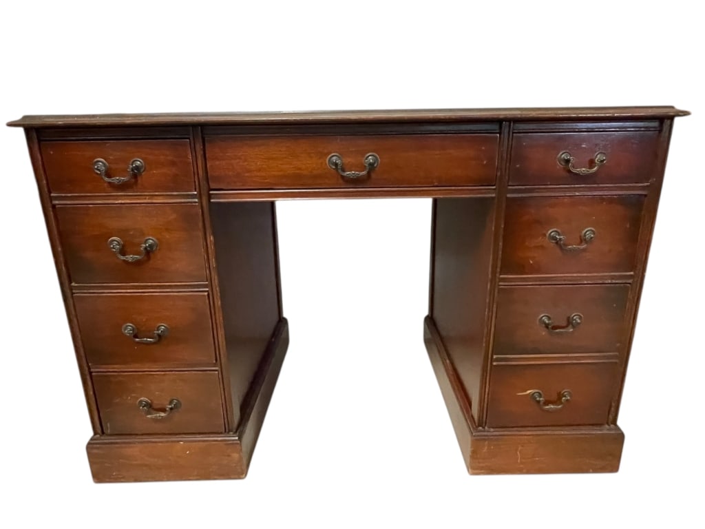 CHIPPENDALE STYLE LEATHER TOP PEDESTAL DESK: This substantial vintage double-pedestal desk is a timeless piece crafted in the Chippendale or Georgian style. The desk features a rich wood finish and a writing surface elegantly inset with a classi