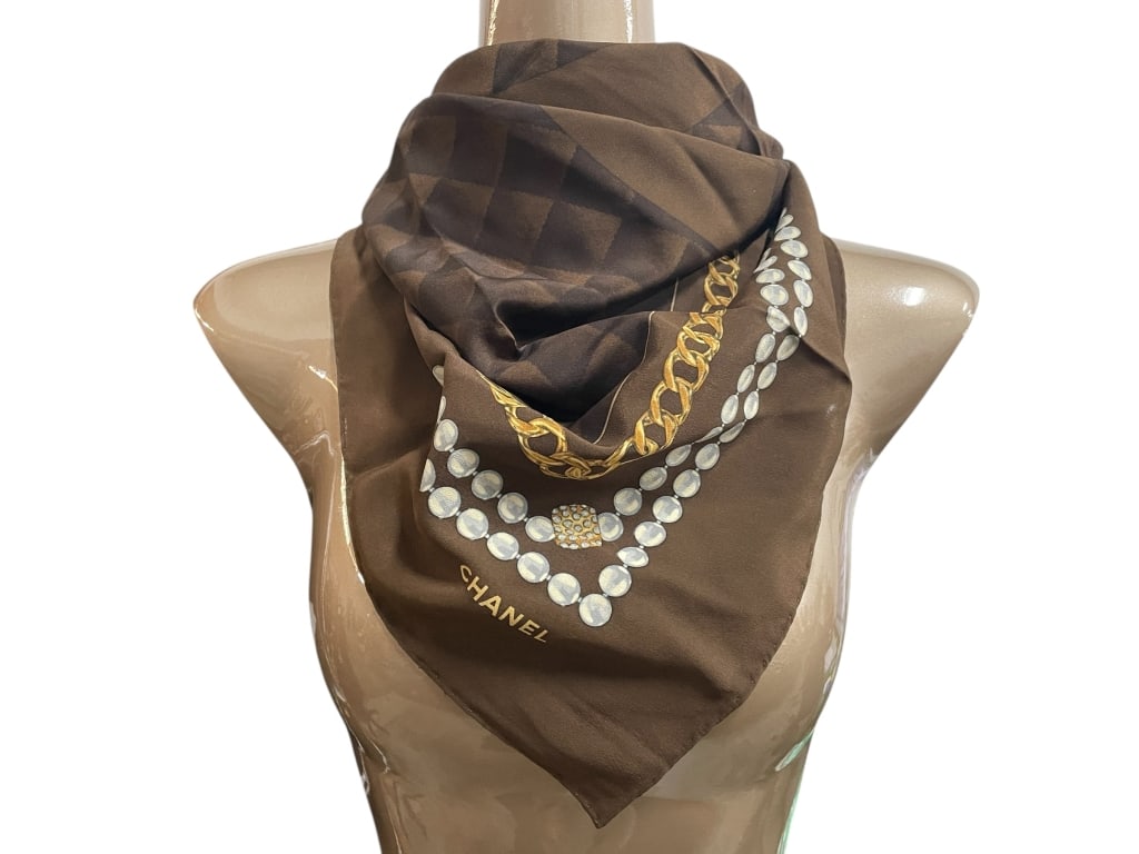 CHANEL BROWN QUILTED CHAIN & PEARL MOTIF SLK SCARF: CHANEL BROWN QUILTED CHAIN AND PEARL MOTIF SILK SCARF -Very good pre owned condition -Approx 33" -Elegant Chanel silk scarf in rich chocolate brown featuring a quilted pattern with the iconic interloc