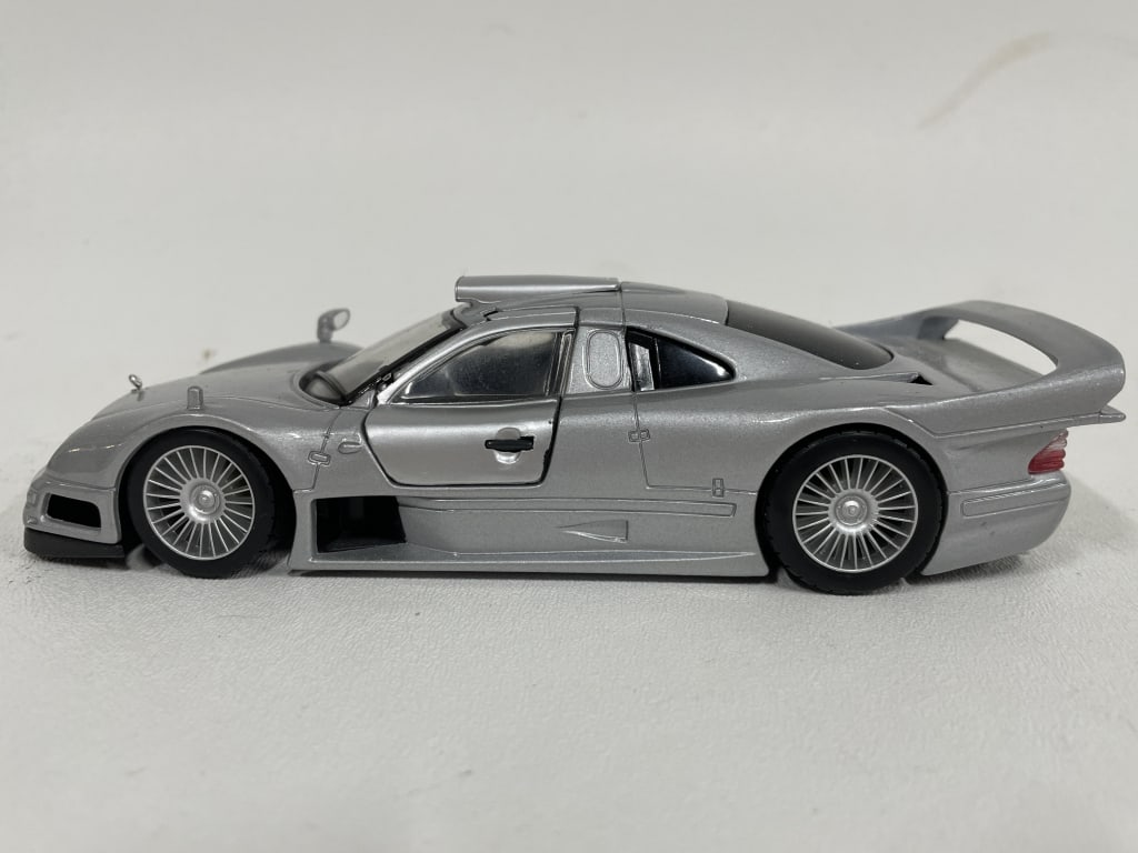 MERCEDES-BENZ CLK GTR DIECAST MODEL CAR 7": MERCEDES-BENZ CLK GTR DIECAST MODEL – SILVER FINISH -Good pre owned condition, missing a mirror -Approx 7"l -Stunning Mercedes-Benz CLK GTR diecast model car in sleek metallic silver. -JA 103025 #De
