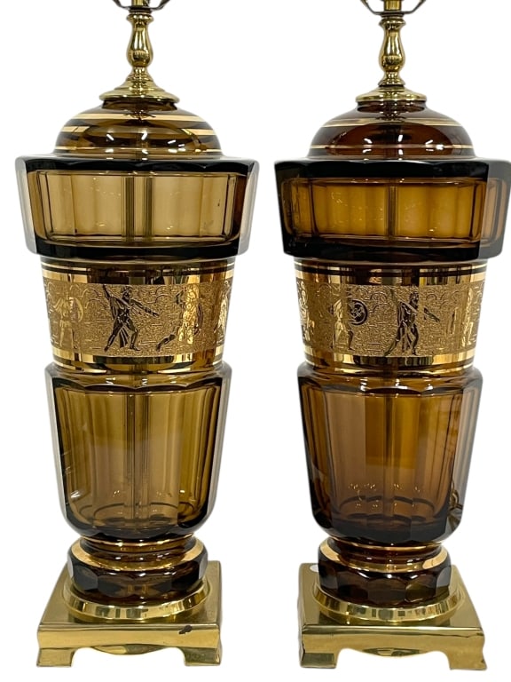 MOSER STYLE AMBER GILDED GREEK WARRIOR: MOSER STYLE AMBER CUT TO CLEAR GLASS LAMPS WITH GILDED GREEK WARRIOR MOTIF, PAIRThis striking pair of Moser-style lamps features rich amber cut-to-clear glass with finely detailed gilt figural bands d