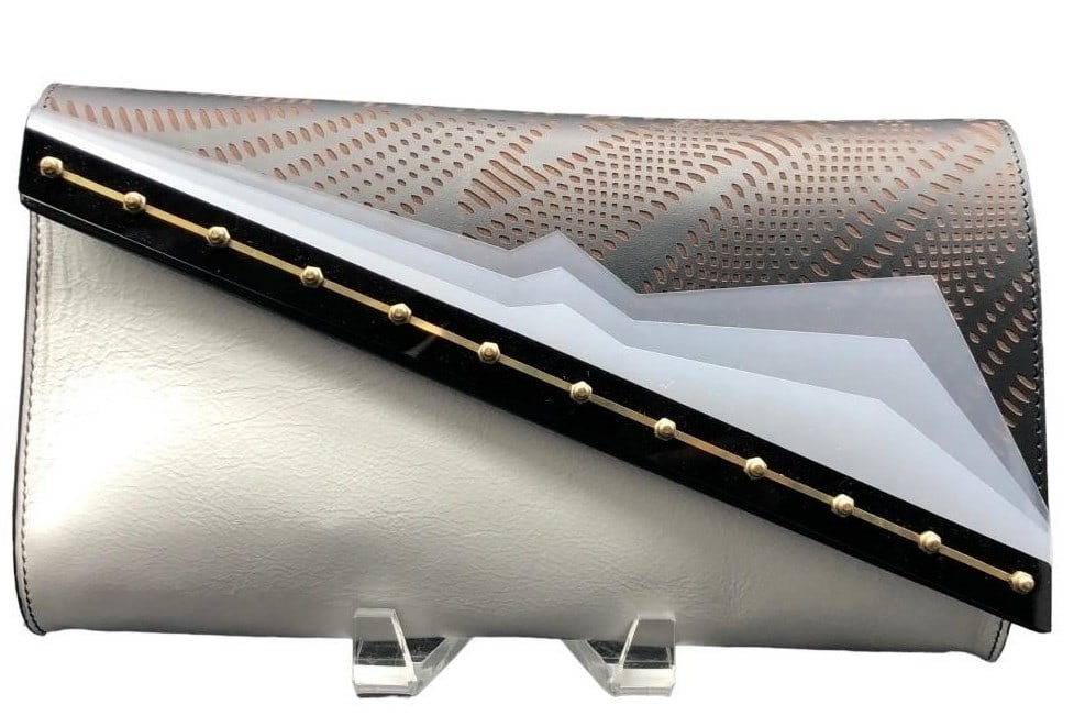 NEW KZENIYA LONDON ASYMMETRIC LEATHER CLUTCH $585: NEW KZENIYA LONDON ASYMMETRIC LEATHER CLUTCH $585 - MADE IN ITALY - COMES WITH TAGS | COLOR: BLK/BRWN/WHITE - LASER CUT LEATHER, PERSPEX ACCENTS - GF 11/2/23 Bidders may pick up their items from the a