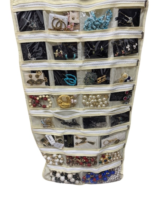 LOT OF COSTUME JEWELRY: LOT OF COSTUME JEWELRY – EARRINGS, BRACELETS, PINS, WATCHES & MOREA large hanging jewelry organizer containing a varied assortment of costume jewelry, including earrings, bracelets, brooches, watche
