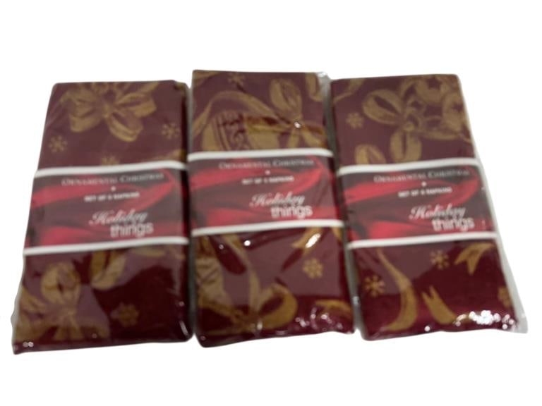 SET OF THREE CHRISTMAS PRINTED FABRIC NAPKINS: SET OF THREE CHRISTMAS PRINTED FABRIC NAPKINS – SEALED =Three coordinating holiday-themed fabric napkins featuring festive ribbon and ornament motifs in rich red and gold tones. New and sealed in or