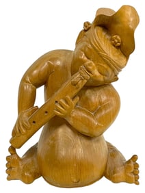 SCULPTURE OF CARVED WOODEN FIGURE PLAYING A FLUTE