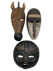 THREE AFRICAN STYLE HAND-CARVED WOODEN MASKS