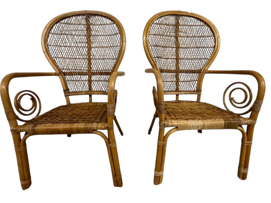 PAIR OF VINTAGE WICKER ARMCHAIRS: PAIR OF VINTAGE WICKER ARMCHAIRS WITH CURVED BACKS AND SEAT CUSHIONS -Pair of vintage wicker armchairs featuring curved backs, woven cane construction, and decorative scroll arm details. Each chair in