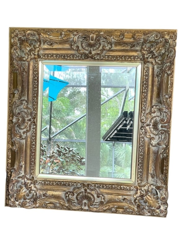ORNATE GILT FRAMED WALL MIRROR W SHELL DETAIL 40": ORNATE GILT FRAMED WALL MIRROR WITH SHELL AND SCROLL DETAILS 40" X 39 -Decorative gilt mirror framed with elaborate shell, scroll, and floral motifs at the corners and crest. A richly detailed accent