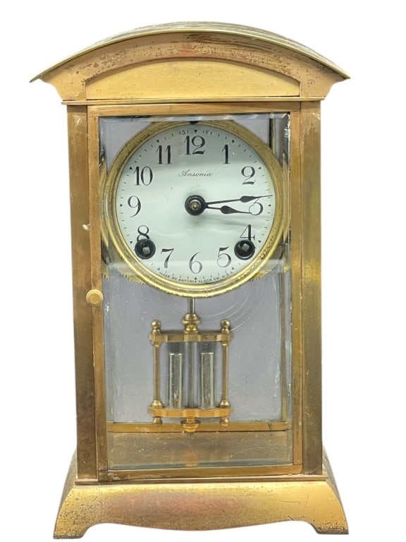 ANSONIA BRASS CARRIAGE CLOCK VISIBLE BALANCE 9.5": ANSONIA BRASS CARRIAGE CLOCK WITH VISIBLE BALANCE – MADE IN USA 9.5" x 6" x 4" approx -Brass carriage clock by Ansonia Clock Co., featuring a white enamel dial with Arabic numerals, visible escapeme