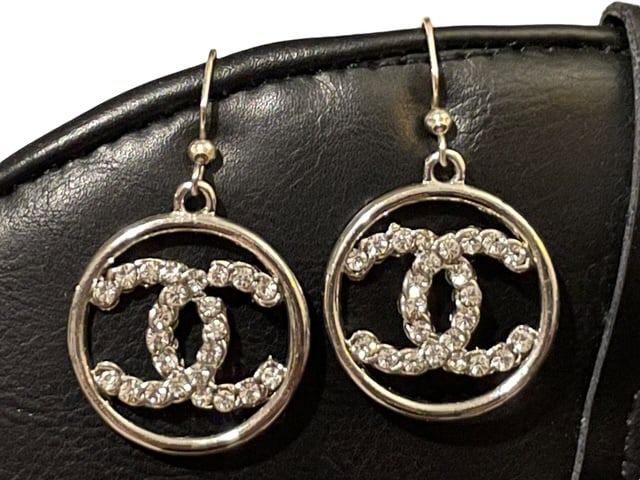 CHANEL CRYSTAL CC IN CIRCLE CHARM EARRINGS SILVER: - CHANEL designer earrings - Charms feature an encircled CC logo with crystals decorating - Hooks for wearing on pierced ears - Signed on back - Charm is 1" in size so with drop about 1.5" drop on the