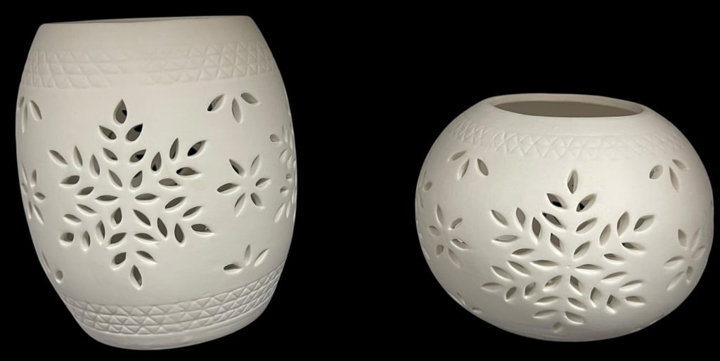 PAIR OF WHITE PIERCED PORCELAIN SNOWFLAKE CANDLE: PAIR OF WHITE PIERCED PORCELAIN SNOWFLAKE VOTIVE CANDLE HOLDERS This lovely pair of white bisque porcelain votive holders features intricate pierced snowflake and floral designs. The set includes one