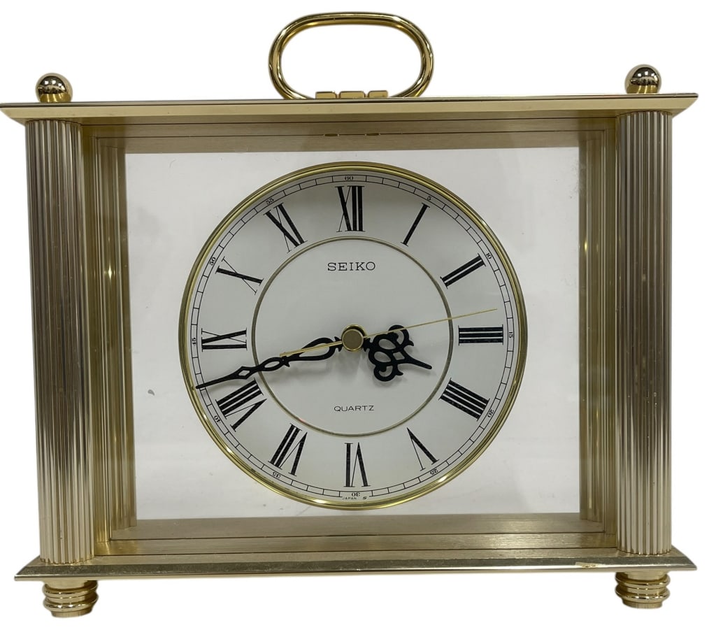 SEIKO QUARTZ BRASS CARRIAGE CLOCK: SEIKO QUARTZ BRASS CARRIAGE CLOCKTHIS ELEGANT SEIKO QUARTZ CARRIAGE CLOCK FEATURES A SOPHISTICATED BRASS-TONE CASE WITH FLUTED SIDE COLUMNS AND A TRADITIONAL TOP CARRYING HANDLE. THE CLOCK FACE