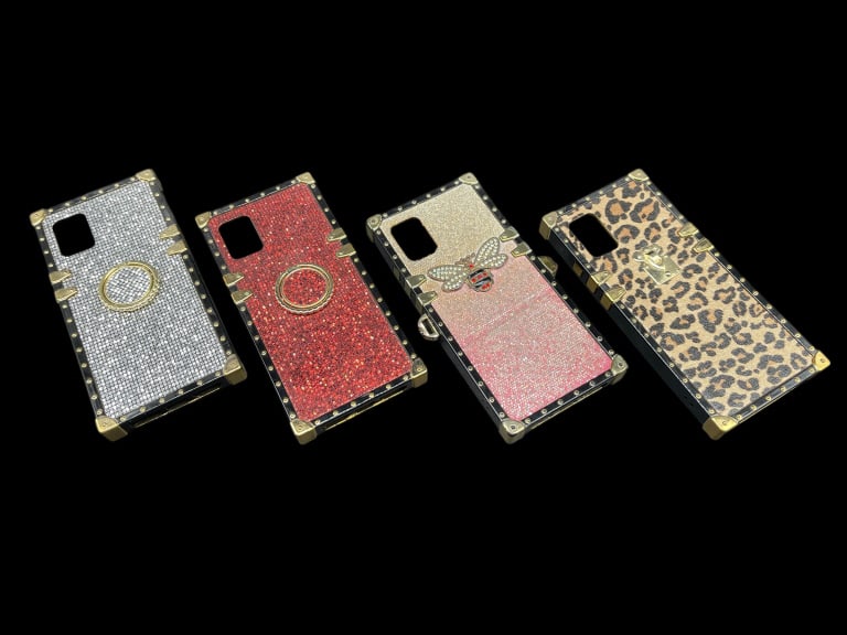SAMSUNG GALAXY A51 5G MODEL CASE COLLECTION: DESIGNER TRUNK-STYLE SMARTPHONE CASE COLLECTION THIS GLAMOROUS LOT FEATURES FOUR PROTECTIVE SMARTPHONE CASES DESIGNED IN A CHIC, VINTAGE TRUNK AESTHETIC WITH REINFORCED GOLD-TONE METAL CORNERS AND STU