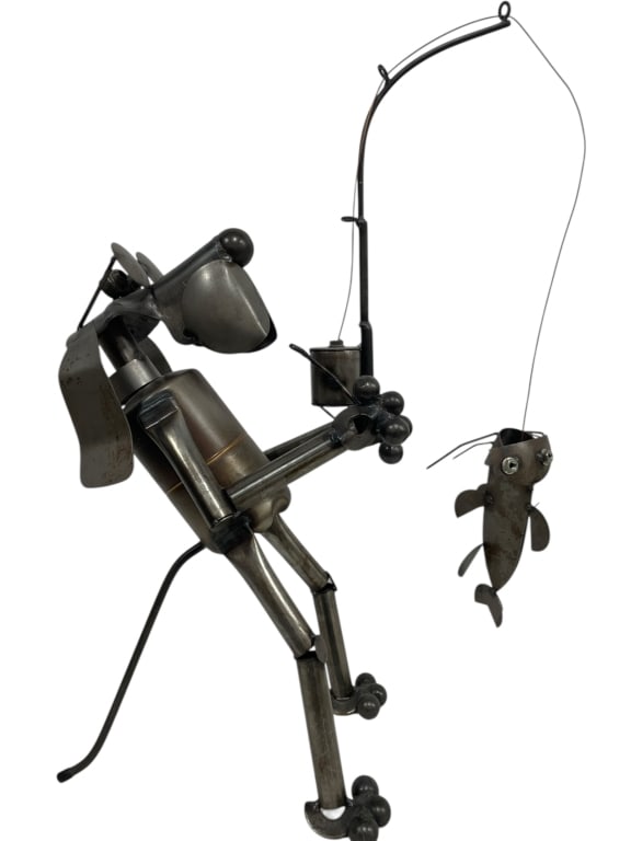 METAL ART SCULPTURE OF DOG FISHERMAN W FISH 29": METAL ART SCULPTURE OF DOG FISHERMAN WITH FISH ON LINE 29" x 12" x 8" approxWhimsical mixed-metal sculpture depicting a stylized fisherman leaning forward with articulated limbs, holding a curved