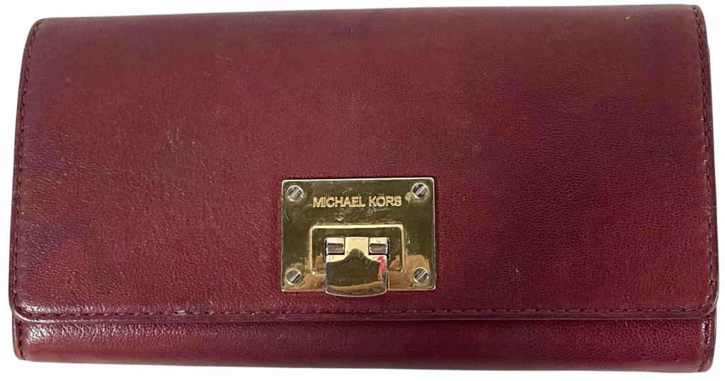 Michael Kors Astrid Carryall Wallet: This red-colored accessory is a Michael Kors Astrid Carryall Wallet, a functional and stylish item designed for women. Product Details Material: It is crafted from high-quality pebbled leather. Design