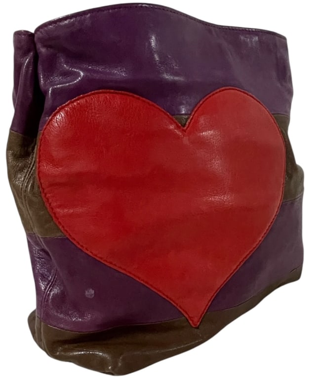 Moschino Cheap and Chic leather tote: Handbag is an authentic Moschino Cheap and Chic leather tote. The bag's distinctive design features bold purple and brown horizontal panels with an oversized red heart appliqué on the front. Designer