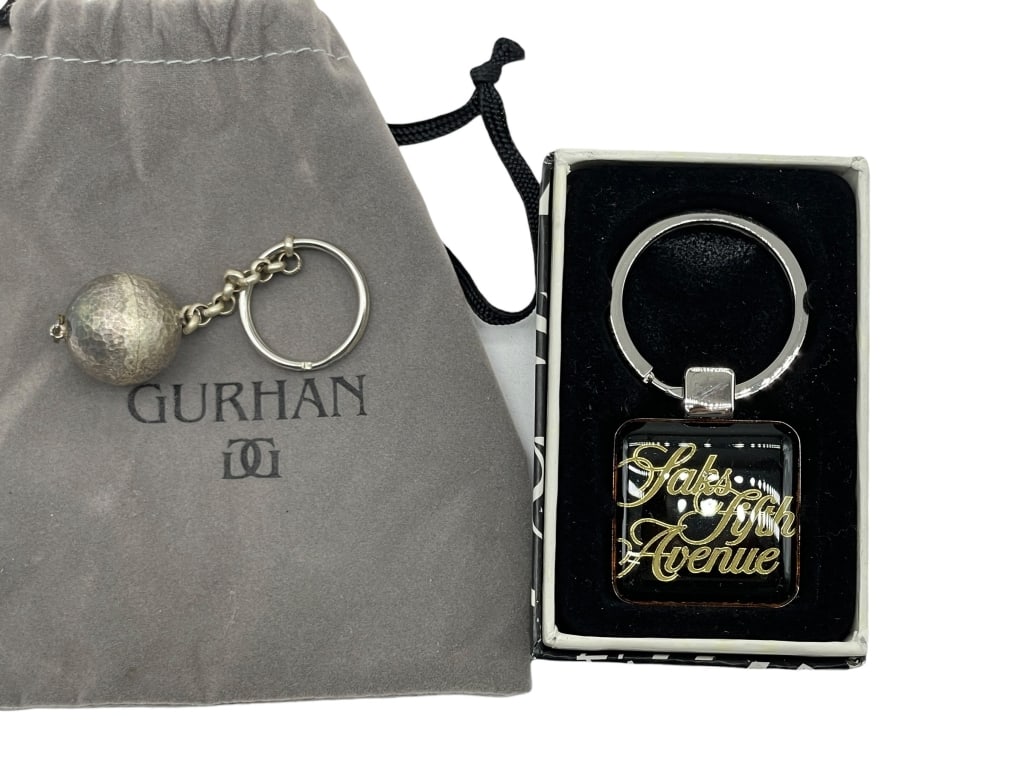 2 DESIGNER KEY RINGS INCLUDING GURHAN AND SAKS: *for competitive shipping options please go to www.dejavuauctionshipping.com -SET OF 2 DESIGNER KEY RINGS INCLUDING GURHAN AND SAKS -Designer accessory lot featuring a hammered sterling silver spheric