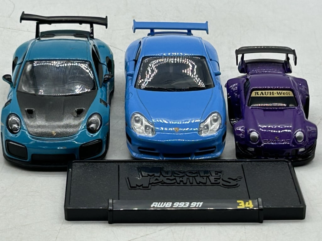 3 MUSCLE MACHINES PORSCHE RWB 993 911 DIECAST LOT: For ALTERNATE shipping quote or LOCAL PICK-UP DETAILS, please visit dejavuauctionshipping.comMUSCLE MACHINES PORSCHE RWB 993 911 DIECAST CAR LOT WITH DISPLAY STANDLot of three diecast Porsche sports