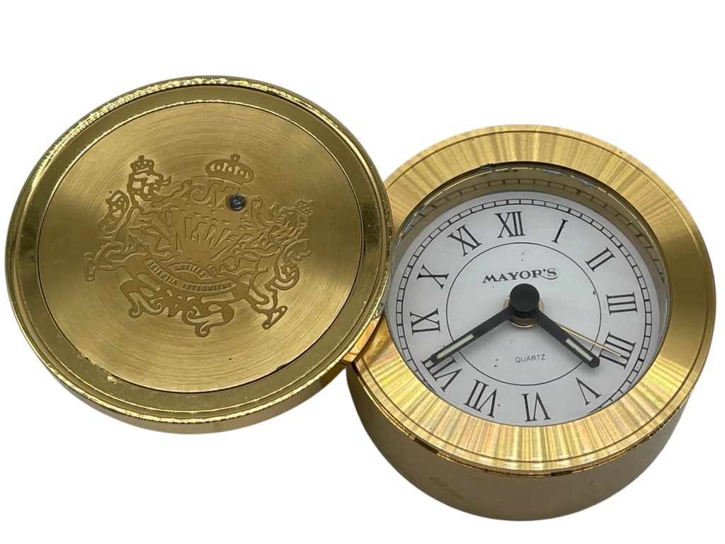 MAYOR’S BRASS QUARTZ DESK CLOCK W/ HINGED COVER: For ALTERNATE shipping quote or LOCAL PICK-UP DETAILS, please visit dejavuauctionshipping.comCompact brass-tone desk clock featuring a hinged lid with engraved crest design and interior quartz