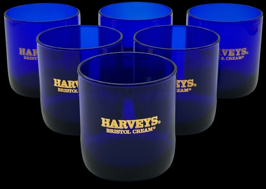 6 HARVEYS BRISTOL CREAM COBALT BLUE GLASS TUMBLERS: SET OF 6 HARVEYS BRISTOL CREAM COBALT BLUE GLASS TUMBLERS Striking set of six cobalt blue glass tumblers featuring the iconic “Harveys Bristol Cream” gold logo, a well-known name in fine sherr