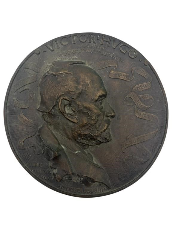 BRONZE RELIEF PLAQUE OF VICTOR HUGO BY RINGEL 6.5": BRONZE RELIEF PLAQUE OF VICTOR HUGO BY RINGEL, DEPICTING A PROFILE PORTRAIT OF THE CELEBRATED FRENCH AUTHOR SURROUNDED BY RIBBON MOTIFS BEARING HIS WORKS—NOTABLY LES MISÉRABLES AND NOTRE-DAME DE PA