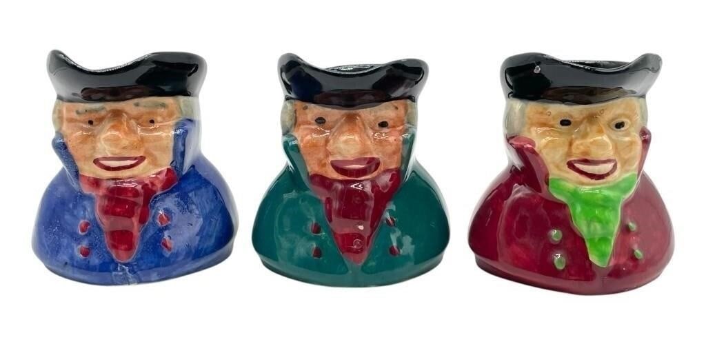 VTG OLD STAFFS TOBY CHARACTER CREAMER TRIO 45": SET OF 3 VINTAGE SHORTER & SON CHARACTER JUGS – THIS COLORFUL TRIO OF HAND-PAINTED CERAMIC JUGS DEPICTS COLONIAL-STYLE GENTLEMEN IN BLUE, GREEN, AND RED COATS WITH BLACK TRI-CORNER HATS. EACH STANDS