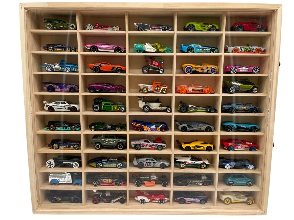 HOT WHEELS DISPLAY CASE WITH 50 DIE CAST CARS: WOODEN DISPLAY CASE FILLED WITH 50 HOT WHEELS DIE CAST VEHICLES Wooden display case filled with 50 Hot Wheels die-cast vehicles, arranged in individual compartments and showcasing a colorful variety o