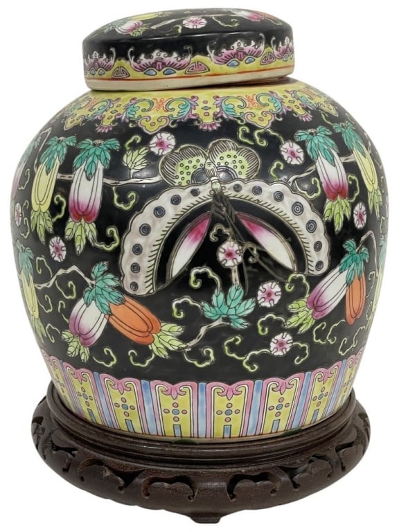 FAMILLE ROSE CHINESE PORCELAIN GINGER JAR 11": BLACK GROUND FAMILLE ROSE STYLE CHINESE PORCELAIN GINGER JAR ON WOOD STAND 11" X 8" D APPROX -Decorative Chinese porcelain ginger jar featuring a striking black ground with colorful famille rose style