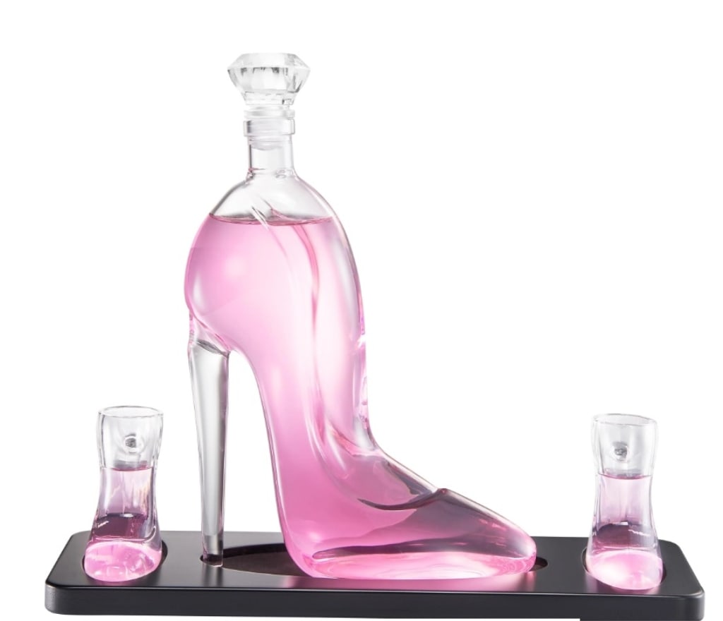 NEW IN BOX! STILETTO HIGH HEEL DECANTER SET: Add a chic twist to your drinkware collection with this stunning Stiletto Glass Decanter Set, designed to turn heads and elevate your hosting game. Made from high-quality borosilicate glass, the 25.36
