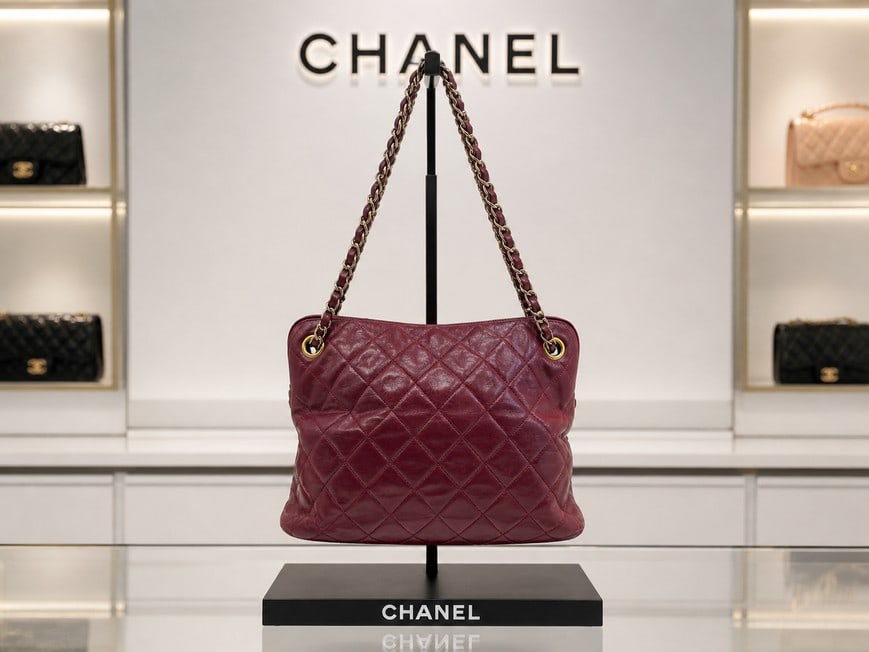 CHANEL DEEP RED PURSE QUILTED LEATHER BAG 10": Chanel vintage quilted shoulder bag in deep burgundy (oxblood) leather, featuring classic diamond quilting and dual chain-link straps threaded with leather. The bag has gold-tone grommets and hardware