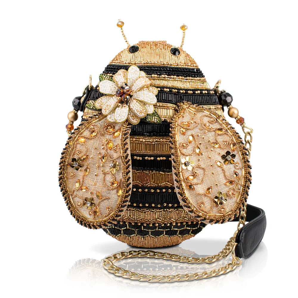 NEW MARY FRANCES SWEET AS HONEY BEE HANDBAG: Buzz into style with this sparkling bee shaped bag, detailed with golden stripes, jeweled wings, and a sweet floral accent. Finished with a chain strap, it’s perfect to wear crossbody or carry as a 
