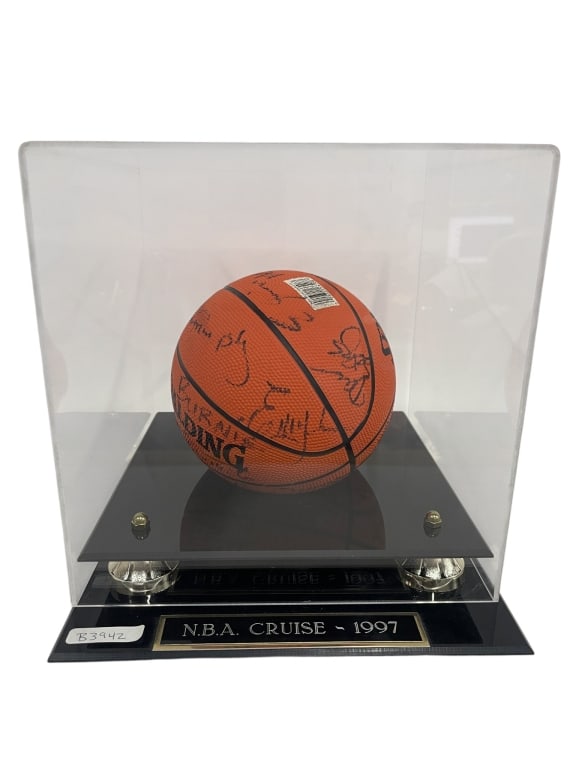 1997 NBA CRUISE SIGNED MINI BASKETBALL IN CASE 12": Souvenir-size Spalding mini basketball displayed in a black acrylic presentation case with plaque reading “N.B.A. Cruise - 1997.” The basketball appears to be signed by multiple individuals,