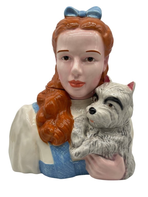 DOROTHY AND TOTO CERAMIC BUST COOKIE JAR 14": Vintage figural ceramic cookie jar depicting Dorothy from The Wizard of Oz holding Toto, featuring a glossy hand-painted finish with red hair, blue bow, blue dress accents, and Toto nestled at her sid