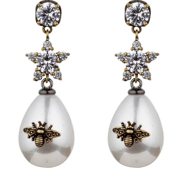 Abeja Earrings Featuring Freshwater Pearl and Bron: Enhance your style with the Abeja Earrings, a perfect blend of elegance and trend. These pieces showcase bronze-toned brass construction with freshwater pearl (man-made) adorned with a detailed bronze