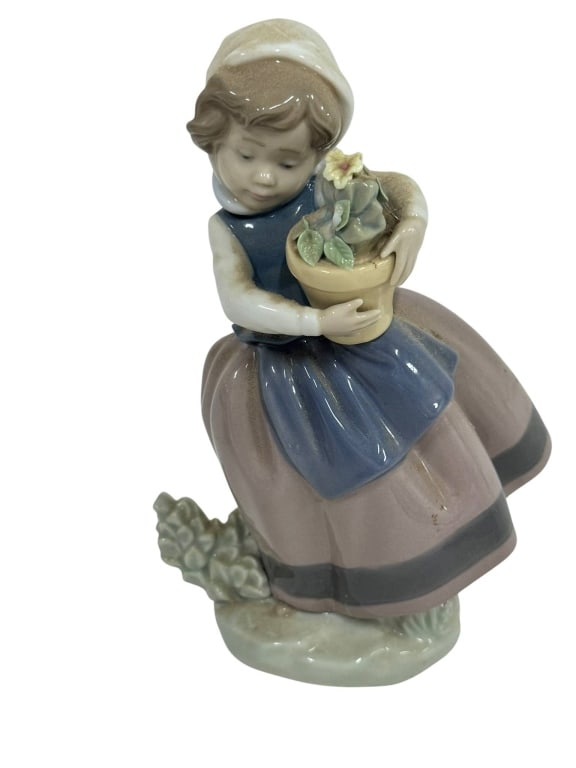LLADRO PORCELAIN GIRL WITH FLOWER POT: Lladro porcelain figurine depicting a girl holding a flower pot. Features hand-painted details and a gloss finish. Marked Lladro on the base. Apro. 6.5" | | -Shipping Available at