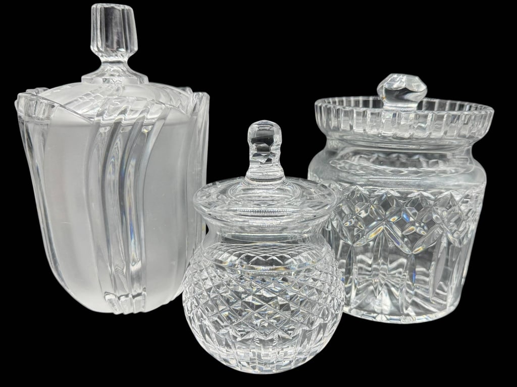 THREE CUT GLASS JARS WITH LIDS: Three cut glass jars with matching lids. Each jar features a distinct pattern and faceted knob handle. The tallest jar measures approximately 8 inches high. Shipping Available at www.DeJaVuAuctionShip