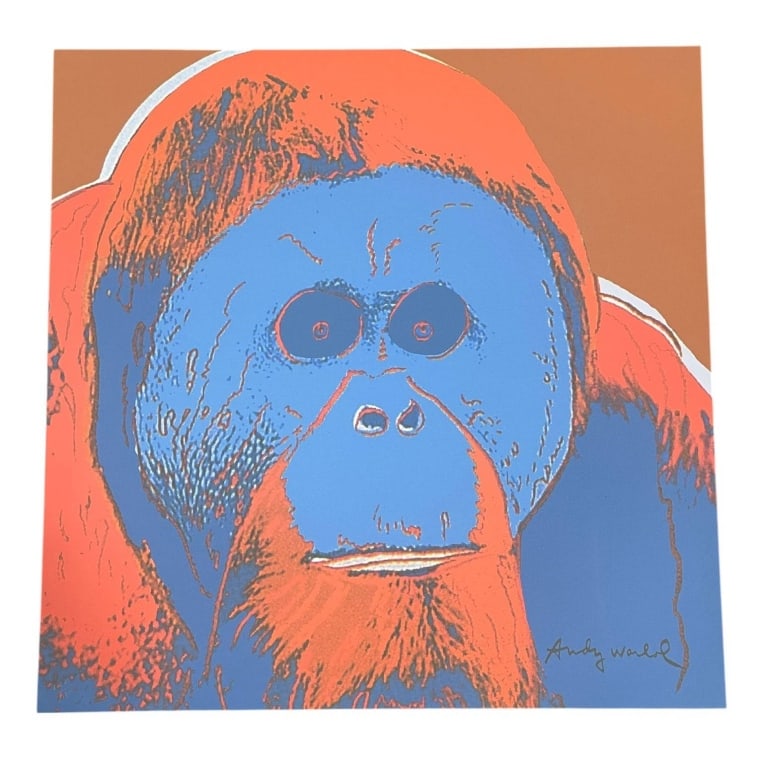 AFTER ANDY WARHOL ORANGUTAN PRINT 23.5": Colorful pop art style print after Andy Warhol, featuring a bold orangutan portrait rendered in vivid blue, orange, coral, and brown tones. The image is inspired by Warhol’s famous Endangered Specie