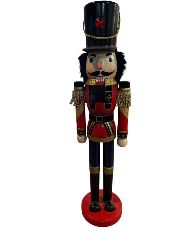 WOODEN NUTCRACKER FIGURE 25 INCHES TALL: Wooden nutcracker figure with painted details, gold accents, and fabric embellishments, measuring approximately 25 inches in height. Shipping Available at www.DeJaVuAuctionShipping.com. By bidding in 