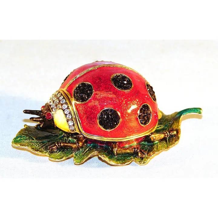 NEW IN BOX LADYBUG JEWELRY BOX ON LEAF: Charming vintage ladybug jewelry or trinket box with red and black enamel and rhinestone detailing, set atop a detailed green leaf. Ideal collectible or decorative item. Shipping Available at www.DeJa