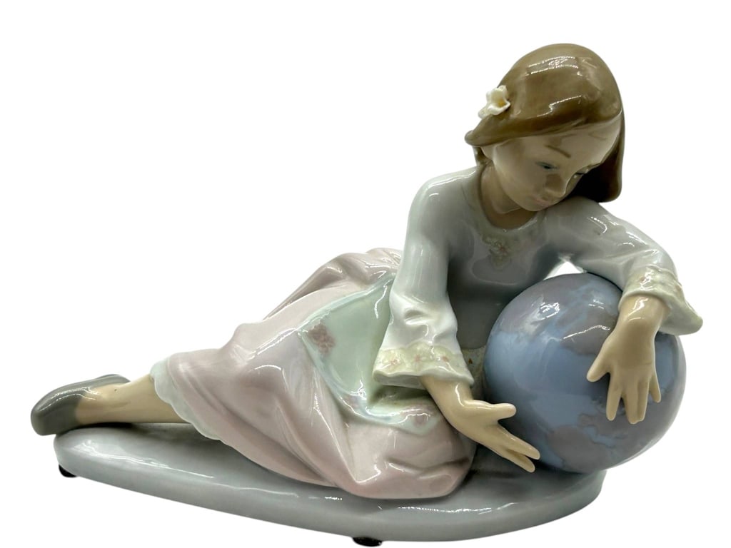 LLADRO PORCELAIN GIRL WITH GLOBE 8": Charming Lladro porcelain figurine depicting a young girl reclining beside a pale blue globe or ball, beautifully finished in soft pastel tones with glossy glaze, delicate facial detail, and graceful 