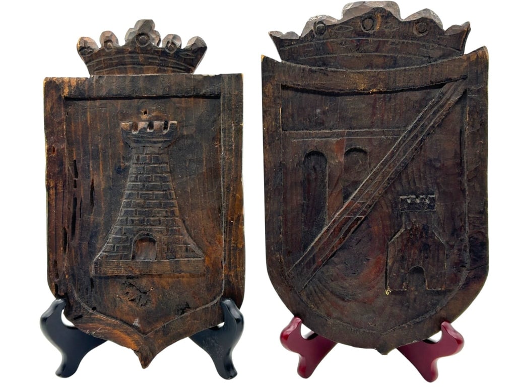 VTG PAIR SPANISH WOOD HERALDIC SHIELD PLAQUES 11": Pair of vintage carved wood heraldic shield wall plaques, made in Spain by Esex S.A., Marques de Cubas, Madrid-14, as shown on the original label. Each plaque features a dark stained carved wood finis